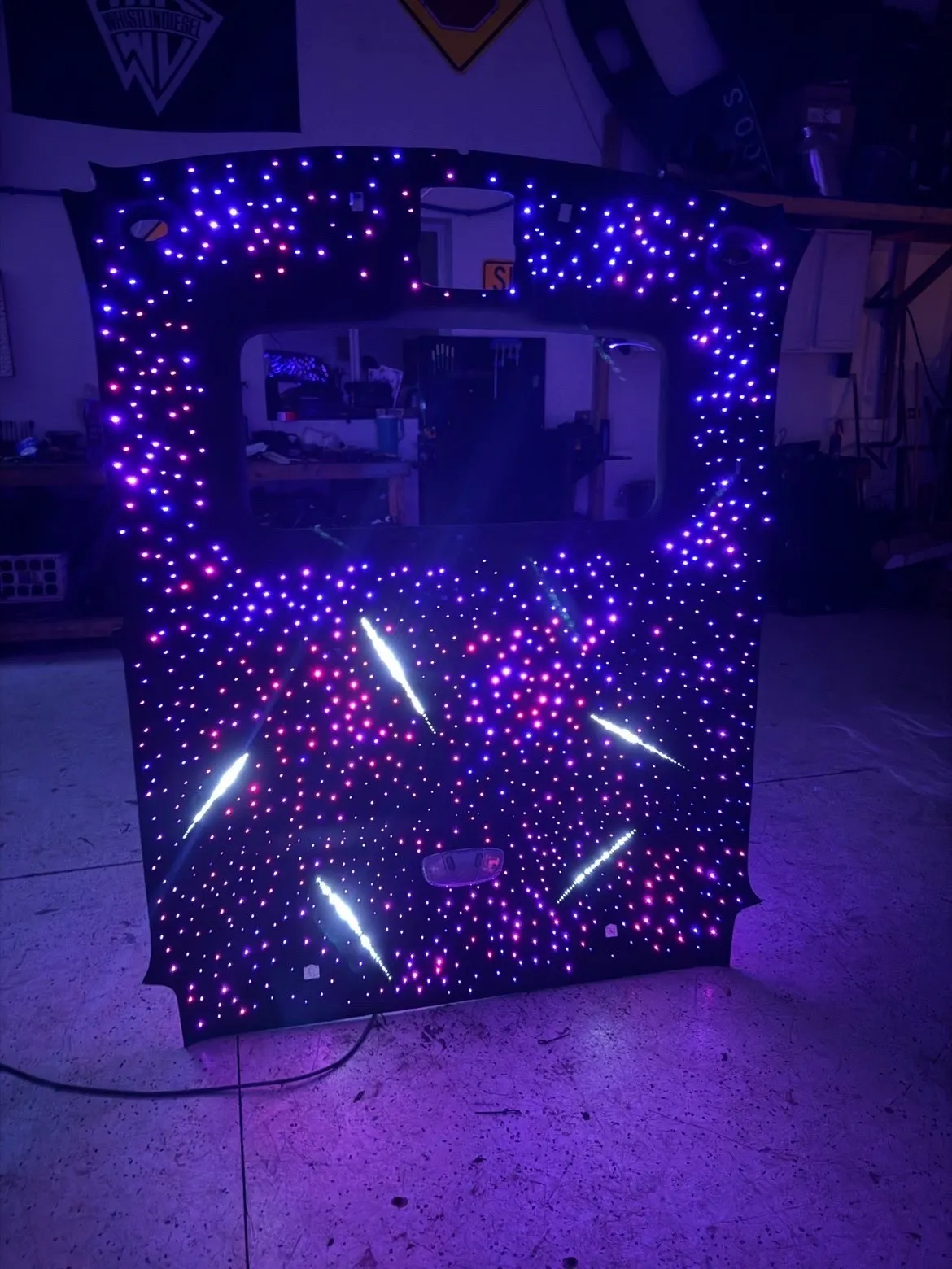 The same headliner lit brightly, hundreds of violet and blue points forming a dense star field with five shooting-star streaks across it.
